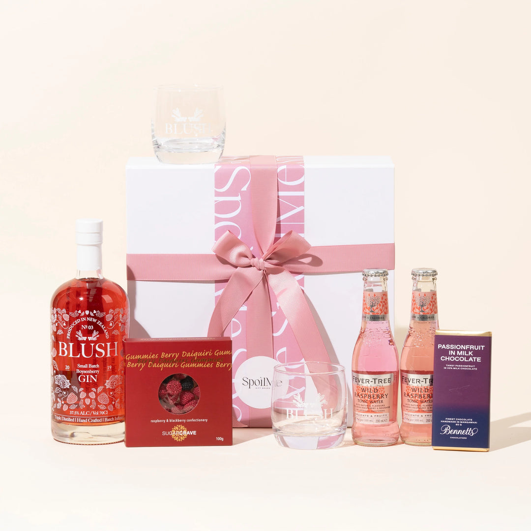 Berry Blush Affair Gift Box A Blush Gin gift box presentation containing a bottle of Blush Boysenberry Pink gin, a branded Blush Gin Glass, two bottles of tonic, a chocolate bar, and lollies, all tied together with a pink ribbon.